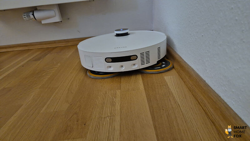 Der Matrix 10 Ultra wischt mit seitlich ausgefahrenem Pad entlang einer Leiste.